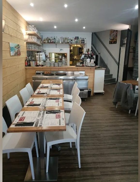 La salle intérieure, tables alignées jusqu’au bar